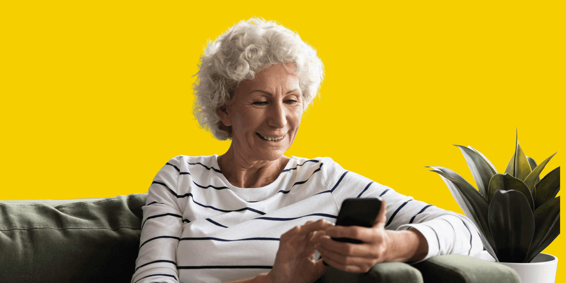 A senior IQ Mobile customer holding an easy-to-use yellow phone